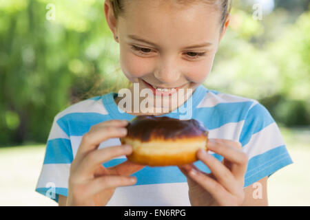 Niedliche kleine Mädchen essen Donut Stockfoto