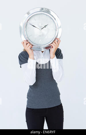 Frau Holding Uhr vor den Kopf Stockfoto