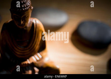 Hölzerne Buddhastatue auf Tisch Stockfoto