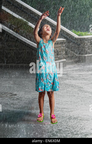 Kleine Mädchen spielen im Regen Stockfoto