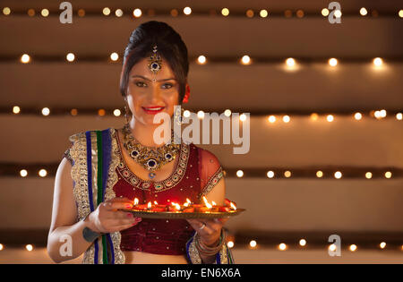 Porträt der Frau mit einem Tablett mit diyas Stockfoto