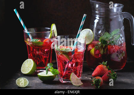 Zwei Gläser mit Retro-Coctail Röhren und Glas Krug Erdbeer Limonade, serviert mit frischen Erdbeeren, Minze und Limette über d Stockfoto