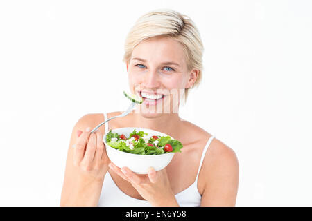 Schöne blonde Frau essen Salat Stockfoto