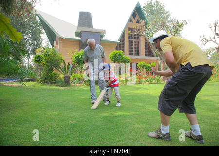 Kleiner Junge spielt Cricket mit Vater und Großvater Stockfoto