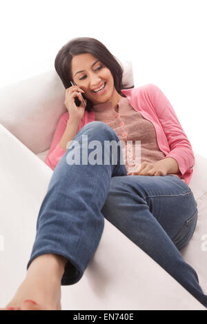 Junge Frau im Gespräch über ihr Handy Stockfoto