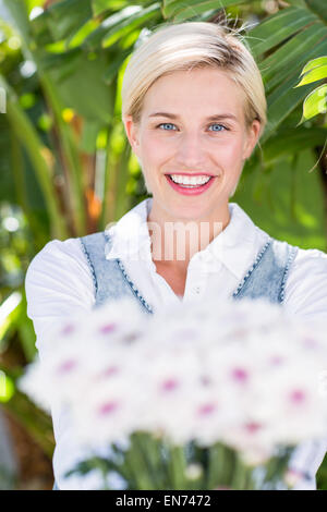 Hübsche blonde Frau mit Blumenstrauß Stockfoto