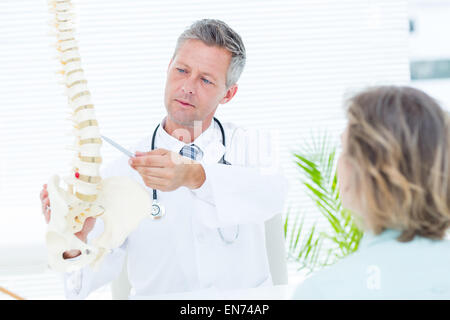 Arzt zeigt seinen Patienten ein Modell der Wirbelsäule Stockfoto