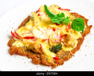 Knusprige Kalbsschnitzel mit Käse, Tomaten, Paprika, Brokkoli und Champignons Stockfoto