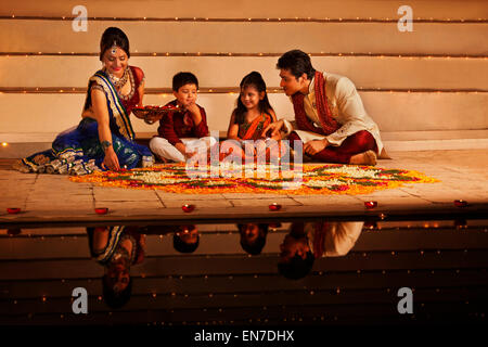 Familie arrangieren Diyas auf rangoli Stockfoto