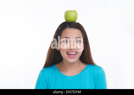 Porträt der Frau Apfel auf dem Kopf balancieren Stockfoto