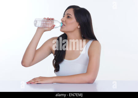 Frau Trinkwasser aus der Flasche Stockfoto