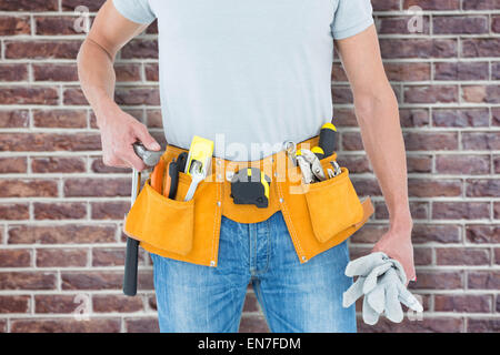 Zusammengesetztes Bild der Techniker halten Handschuhe und hammer Stockfoto