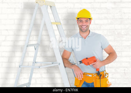 Zusammengesetztes Bild glücklich Handwerker mit Bohrmaschine stützte sich auf Leiter Stockfoto