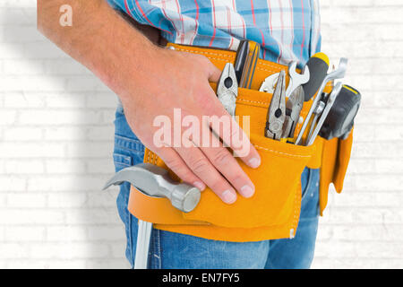 Zusammengesetztes Bild des Mittelteils des Handwerker tragen Werkzeuggürtel Stockfoto