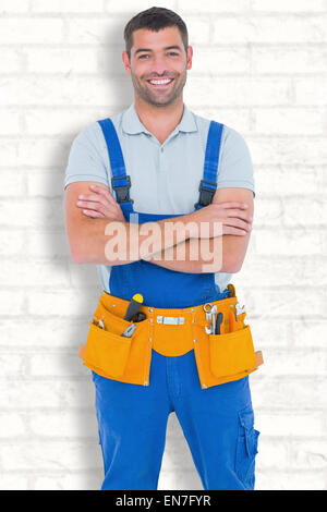 Zusammengesetztes Bild der Mechaniker in Overalls tragen Werkzeug Gürtel stehend Arme gekreuzt Stockfoto