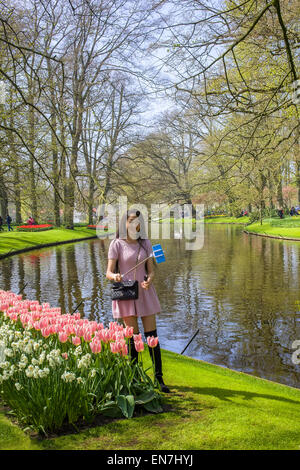 Japanische Touristen nehmen Selfie neben Tulpen in den Keukenhof in den Niederlanden Stockfoto