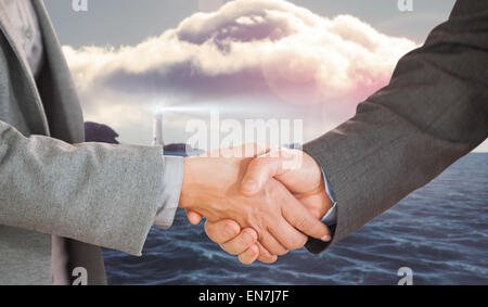 Zusammengesetztes Bild zweier Menschen, die mit einem Handschlag in einem Büro Stockfoto
