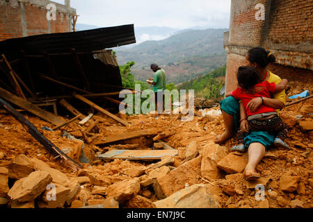 Sindhupalchowk, Nepal. 29. April 2015. Eine Frau und ihr Kind sitzen auf den Trümmern ihres Hauses nach Erdbeben im Sindhupalchowk Bezirk, Nepal, 29. April 2015. Bis zum Mittag am Mittwoch hatte mehr als 1.376 Menschen bereits tot in Sindhupalchowk Bezirk allein, etwa 100 km entfernt von der Hauptstadt bestätigt, die an China grenzt. © Pratap Thapa/Xinhua/Alamy Live-Nachrichten Stockfoto