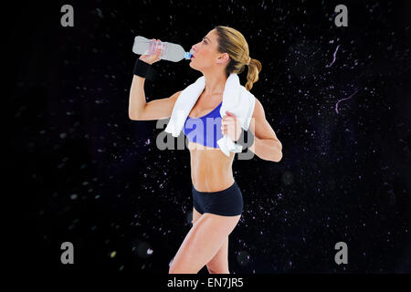 Zusammengesetztes Bild starke blonde aus Flasche Wasser trinken Stockfoto