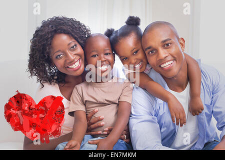 Zusammengesetztes Bild der glücklichen Familie posiert auf der Couch zusammen Stockfoto