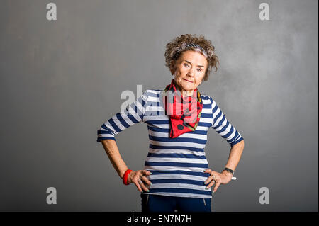 Studioportrait von 83 alte suchen gute weiße senior Frau auf grauem Hintergrund Stockfoto