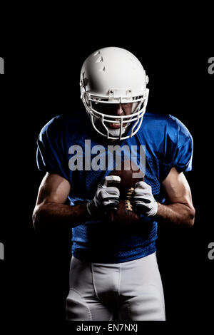 Fußballspieler mit auf eine blaue Uniform und ein Ball in der Hand. Studio gedreht. Stockfoto
