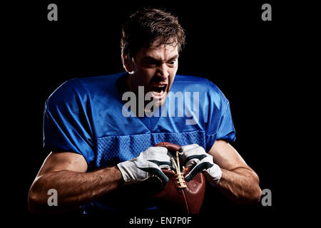 Fußballspieler mit auf eine blaue Uniform und ein Ball in der Hand. Studio gedreht. Stockfoto