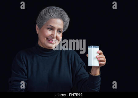Alte Frau mit Glas Milch Stockfoto