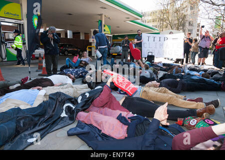 Demonstranten durchführen "Sterben In" bei BP / British Petroleum Benzin füllen Bahnhofsvorplatz während einer Demokratie Vs TTIP Day of Action. Stockfoto