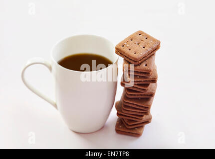 Kaffeetasse mit Stapel der Kekse auf weißem Hintergrund Stockfoto