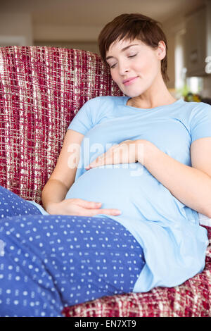 Schwangere Frau auf der Couch entspannen Stockfoto