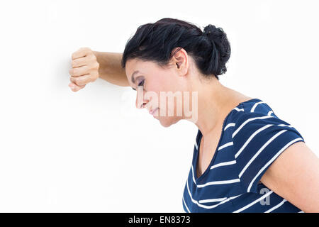 Traurige Frau an die Wand gelehnt Stockfoto