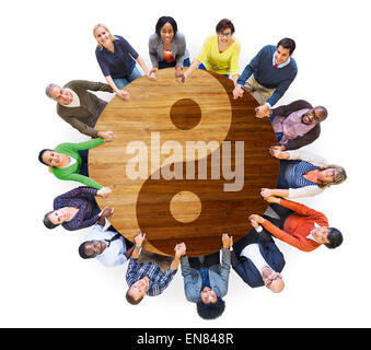 Multiethnische Menschen Hand in Hand mit Yin Yang Symbol Stockfoto