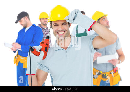 Zusammengesetztes Bild des schönen Architekten halten Bohrmaschine Stockfoto