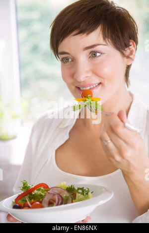 Schwangere Frau, die Schüssel Salat Stockfoto