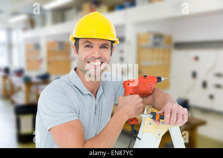 Zusammengesetztes Bild glücklich Techniker halten Bohrmaschine und stützte sich auf Leiter Stockfoto