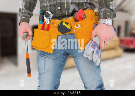 Zusammengesetztes Bild der Arbeiter halten Handschuhe und hammer Stockfoto