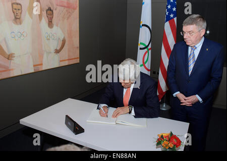 International Olympic Committee Präsident Thomas Bach schaut zu, wie US-Außenminister John Kerry unterschreibt das Gästebuch im Olympischen Museum in Lausanne, Schweiz, am 21. März 2015, bevor die Sekretärin die Anlage besichtigten und behandelt das internationale Presse-Korps, die es während seines einwöchigen Verhandlungen mit iranischen Führer über die Zukunft der ihr Atomprogramm gearbeitet hatten. Stockfoto