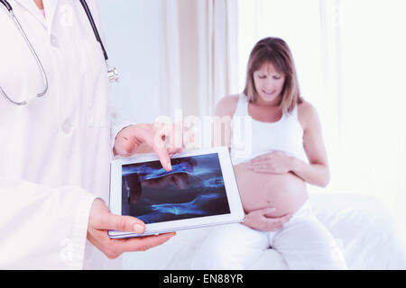 Zusammengesetztes Bild des Arztes betrachten Xray auf tablet Stockfoto