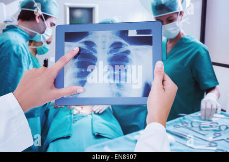 Zusammengesetztes Bild des Arztes betrachten Xray auf tablet Stockfoto