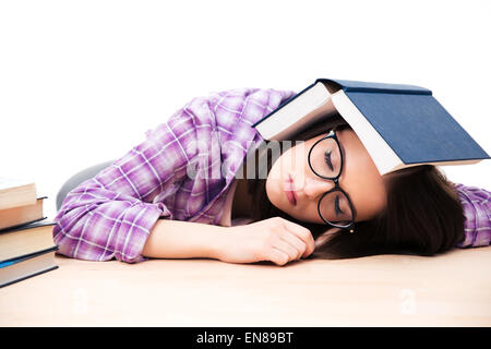 Junge Studentin mit Buch auf dem Tisch zu schlafen, auf weißem Hintergrund Stockfoto