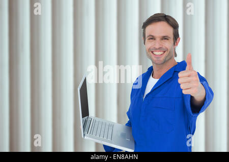 Zusammengesetztes Bild des mechanischen Betrieb Laptop beim Daumen auftauchen Stockfoto