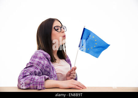 Junge Frau bläst auf die europäische Flagge auf weißem Hintergrund Stockfoto