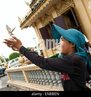 Verkauf von Vögel für religiöse Zwecke in Phnom Penh, Kambodscha, Asien. Ein Junge gekauft und frei den Vogel nach der buddhistischen Stockfoto