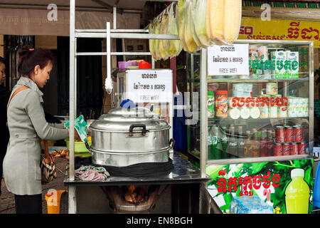 Eine junge kambodschanische Frau Kochen und verkaufen Mais Maiskolben auf der Straße Restaurant in Phnom Penh, Kambodscha, Asien. Stockfoto