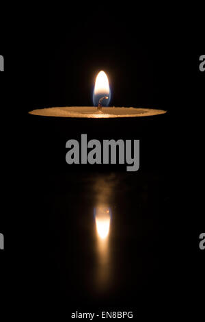 Teelicht Licht und Reflexion vor einem dunklen Hintergrund Stockfoto