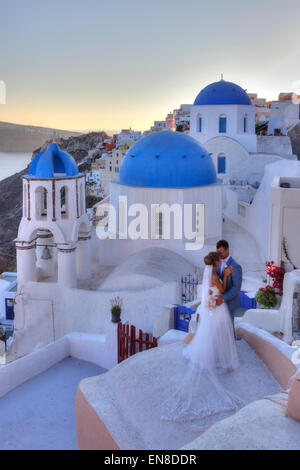 Brautpaar mit traditionellen Kirche in Oia, Santorini, Griechenland Stockfoto