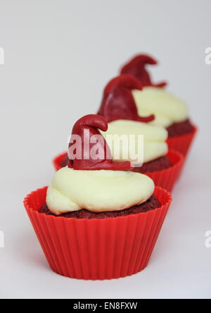Isolierte Reihe von red Velvet Cupcakes mit Frischkäse-Glasur Stockfoto