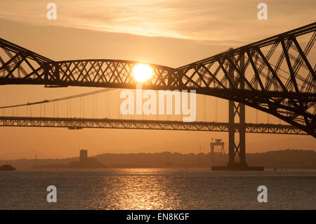 Vierte Schiene Brücke Silhouette mit Sonne absetzen und Reflexion in den Fluss, South Queensferry, Edinburgh, Schottland Stockfoto