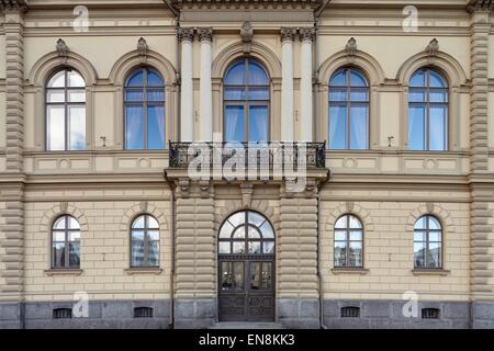 Alte klassische Fassade mit Fenstern, Balkon und sehr schöne Tür. Blauer Himmel Reflexionen in den Fenstern. Stockfoto